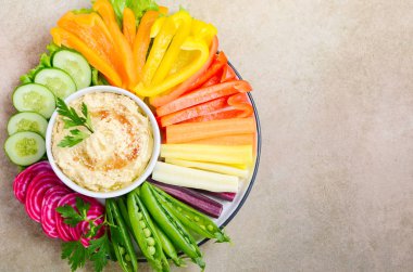 Humus tabağı ve çeşitli sebze atıştırmalıkları. Sağlıklı vejetaryen ve vejetaryen yemekleri. Üst görünüm, düz görünüm, kopyalama alanı.