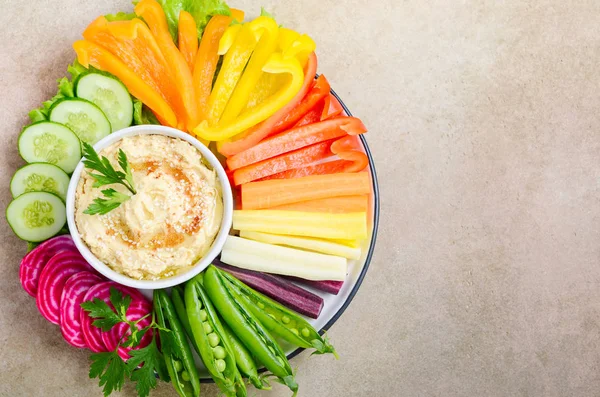 Humus tabağı ve çeşitli sebze atıştırmalıkları. Sağlıklı vejetaryen ve vejetaryen yemekleri. Üst görünüm, düz görünüm, kopyalama alanı.