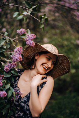 Leylağın yanındaki şapkalı neşeli bir kızın portresi..