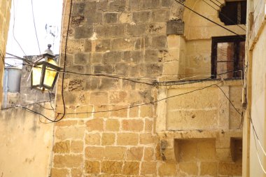 Lamba ve küçük balkon Malta 'da eski bir tuğla evin önünde.
