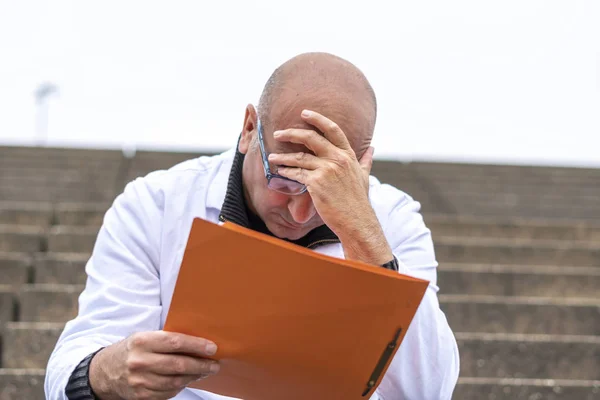 仕事の問題だ書類上の悪いニュースを読むことに直面して絶望的 失望した医療従事者 — ストック写真