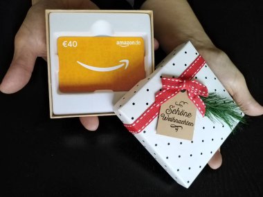 Berlin, Almanya - 5 Aralık 2019: Amazon.de hediye kartı ve Noel kutusu. 1994 yılında kurulan Amazon.com, online alışveriş yapan bir Amerikan elektronik ticaret ve bulut bilgisayar şirketidir. Düz Yat