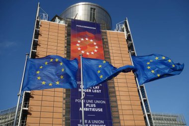 Brüksel, Belçika - 24 Aralık 2019: Avrupa Birliği bayrakları Avrupa Komisyonu karargahı olan Berlaymont binasının önünde dalgalanıyor