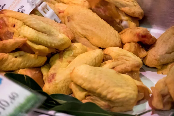 Raw chicken for sale in a butcher\'s shop counter