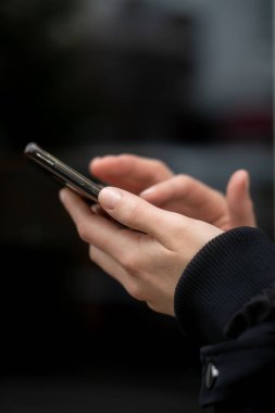 bir akıllı telefon kullanan bir kadın elinde