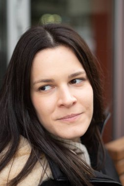 Close-up portrait of an attractive young brunette woman looking away