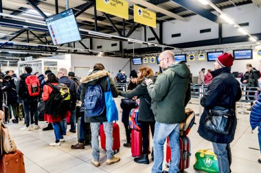 Berlin, Germany - February 3, 2020: Check in at airport. People in a row at the check in counters at the airport