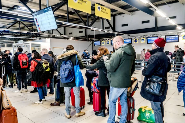 Berlin, Germany - February 3, 2020: Check in at airport. People in a row at the check in counters at the airport