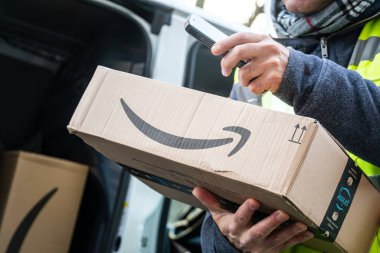 Berlin, Almanya - 27 Ocak 2020: iş vardiyası sırasında barkodları tarayan bir Amazon Prime kurye ajanının görüntüsü. Amazon bir Amerikan elektronik ticaret şirketidir.