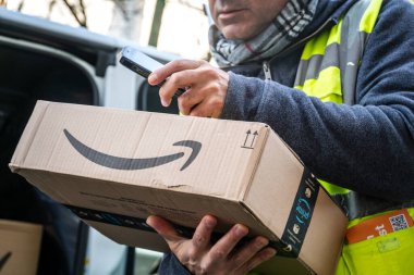 Berlin, Almanya - 27 Ocak 2020: iş vardiyası sırasında barkodları tarayan bir Amazon Prime kurye ajanının görüntüsü. Amazon bir Amerikan elektronik ticaret şirketidir.