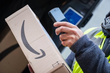 Berlin, Almanya - 27 Ocak 2020: iş vardiyası sırasında barkodları tarayan bir Amazon Prime kurye ajanının görüntüsü. Amazon bir Amerikan elektronik ticaret şirketidir.
