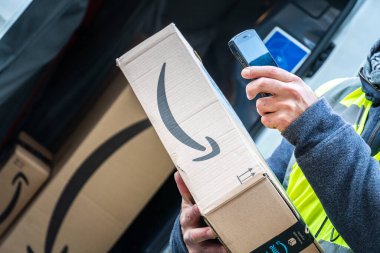 Berlin, Almanya - 27 Ocak 2020: iş vardiyası sırasında barkodları tarayan bir Amazon Prime kurye ajanının görüntüsü. Amazon bir Amerikan elektronik ticaret şirketidir.