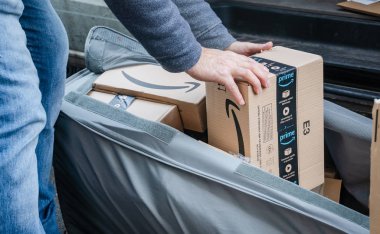 Berlin, Germany - January 27, 2020: Cropped shot of an Amazon Prime delivery agent during his work shift. Amazon is an American electronic online commerce company
