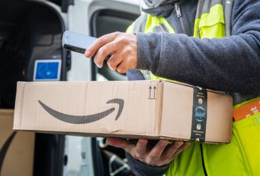 Berlin, Almanya - 27 Ocak 2020: iş vardiyası sırasında barkodları tarayan bir Amazon Prime kurye ajanının görüntüsü. Amazon bir Amerikan elektronik ticaret şirketidir.