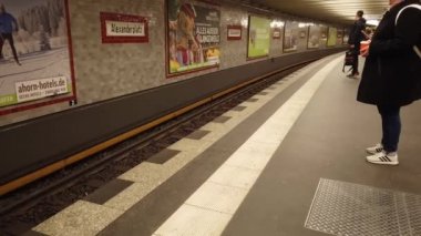 Berlin, Germany - January 9, 2020: People waiting for the arriving train on the platform in a U-Bahn railway station. The Berlin U-Bahn is a rapid transit railway