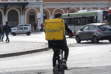 Bari, İtalya - 4 Şubat 2020: Glovo teslimatçısı bisikletle iş başında. Glovo bir İtalyan çevrimiçi yemek dağıtım şirketi.