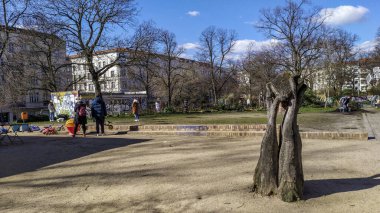 Berlin, Almanya - 14 Mart 2020: Halk ve çocuklar, Prenzlauer Berg bölgesinde küçük yeşil bir meydan olan Helmholtzplatz 'da oyun alanının keyfini çıkarıyorlar