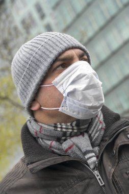 Hastalık salgını, Coronavirus covid-19 salgını. Yüzünde cerrahi koruyucu maske olan yetişkin bir adamın portresi.