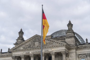 Berlin 'deki Reichstag binasının (Bundestag) önündeki üç renkli Alman bayrağı Alman halkına ithafen Dem Deutschen Volke
