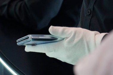 Berlin, Almanya - 10 Eylül 2019: Samsung 'un katlanabilir akıllı telefonu Galaxy 5G' yi tutan beyaz bir eldivenle kaplı