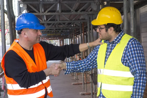 建筑工人和年轻建筑师在建筑工地握手 — 图库照片