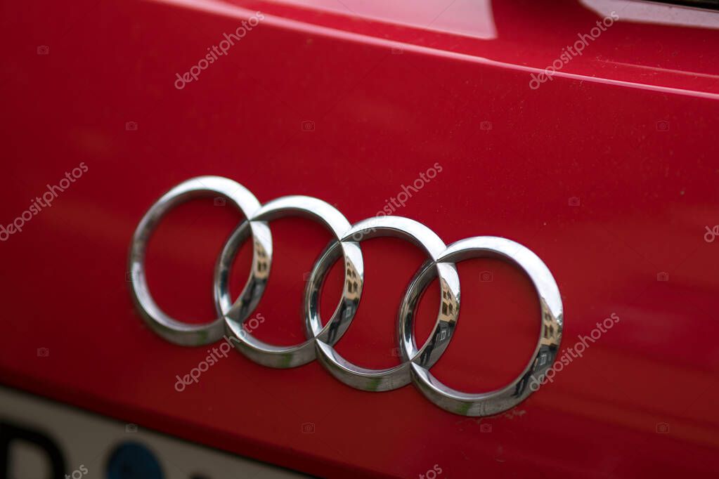 Berlin, Germany - April 29, 2020: Audi company emblem on red car. Audi AG is a premium German automobile manufacturer that designs, engineers, produces, markets and distributes luxury automobiles