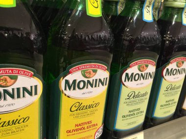 Berlin, Almanya - 3 Nisan 2017: Monini zeytinyağı şişeleri süpermarket rafında. 1920 yılında Spoleto, İtalya 'da kurulan şirket zeytinyağı üretiyor.