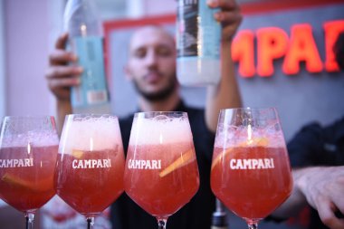 Berlin, Almanya - 19 Haziran 2019: Spritz kokteyl aperatifini hazırlamak, Campari likörü ve ros şarabını veya Prosecco 'yu buz ve limon tekerleriyle dolu bardaklara doldurmak