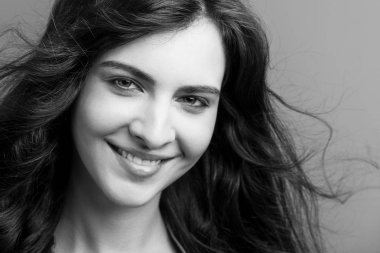 Gülümseyen güzel bir kadının siyah beyaz portresi.