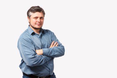 Gri saçlı, 30 'larında genç bir adam çapraz kollu kameraya bakıyor.