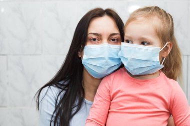 Karantinaya alınmış kadın ve bebek tıbbi maske takıyor. Odaktaki bebek.