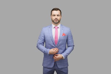 Yakışıklı adam gri arka planda mavi takım elbise giyiyor..