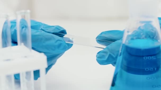 Gros plan d'une main en gants de caoutchouc bleu d'un grand laboratoire de recherche — Video