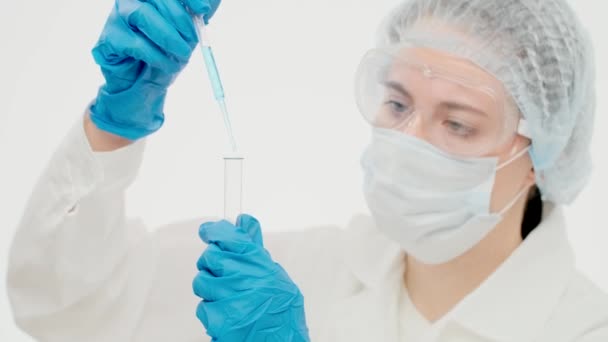 Lovely caucasian female scientist in laboratory puts a blue faci — Stock Video