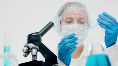 Koruyucu ekipmanlarda sevimli laboratuar asistanı damlalardan örnek alıyor