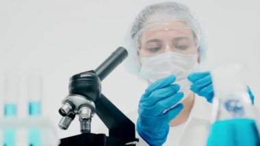 Genç kadın üreme kliniği çalışanı biyolojik sa 'yı inceliyor.