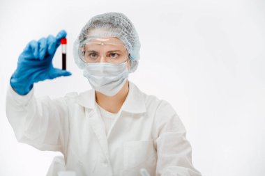 Üniformalı kadın bilim adamı klinikte koronavirüslü kan tüpü tutuyor.