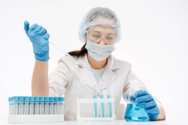 Maskeli ve gözlüklü kadın laboratuarda koronavirüs testi yapmak için örnek alıyor.