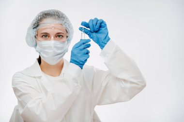 Maskeli kadın Coronavirus 'u tedavi etmek için eldiven ve ilaç taşıyor.