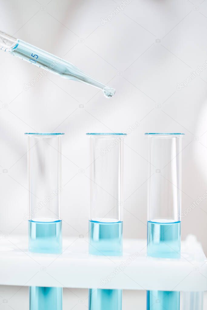 clean glass tubes and pipette with light blue reagent for coronavirus test