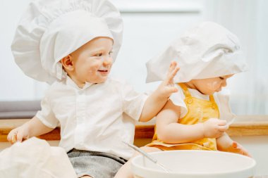 Beyaz şapkalı neşeli, beyaz tenli çocuklar.