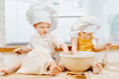 Beyaz şapkalı iki yaşındaki ikiz kardeş.