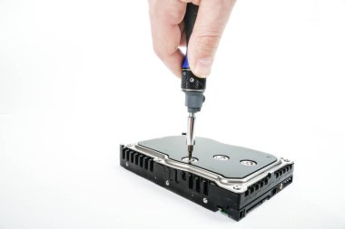 El tamirci 3,5 inç sabit disk kapağı bir tornavida ile unscrews..