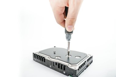 El tamirci 3,5 inç sabit disk kapağı bir tornavida ile unscrews..