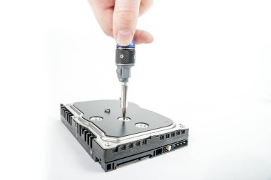 El tamirci 3,5 inç sabit disk kapağı bir tornavida ile unscrews..
