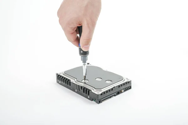 El reparador de mano desenrosca la cubierta del disco duro de 3,5 pulgadas con un destornillador . — Foto de Stock