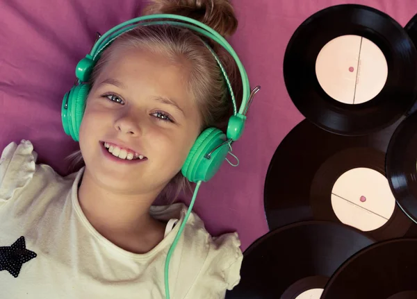 Vinil kayıtlar yanında yalan ve kulaklıklar müzik dinlemek güzel kız.