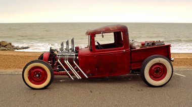 Classic Hot Rod  pickup truck on seafront promenade with sea in background clipart