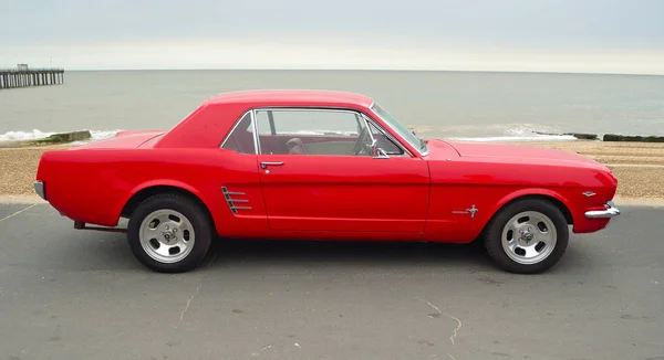 Klasik kırmızı Ford Mustang sahil gezinti yerinde Park.