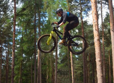 Haynes, Bedfordshire, İngiltere - 14 Mayıs 2017: Freestyle Stunt bisikletçi orta hava çok yüksek ağaçlar arka planda ile. 